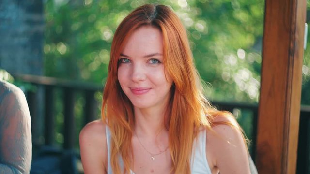 Young caucasian woman with red hair smiling and making faces