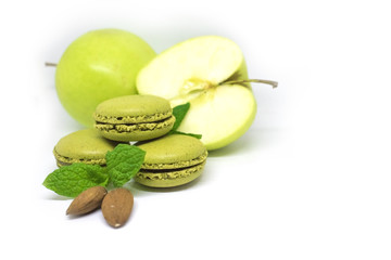 French cookie macaroons with juicy green apple, almonds and mint leaves on white background