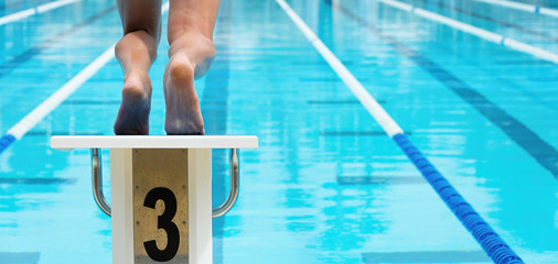 The swimmer jumps from the start block at the start of the race