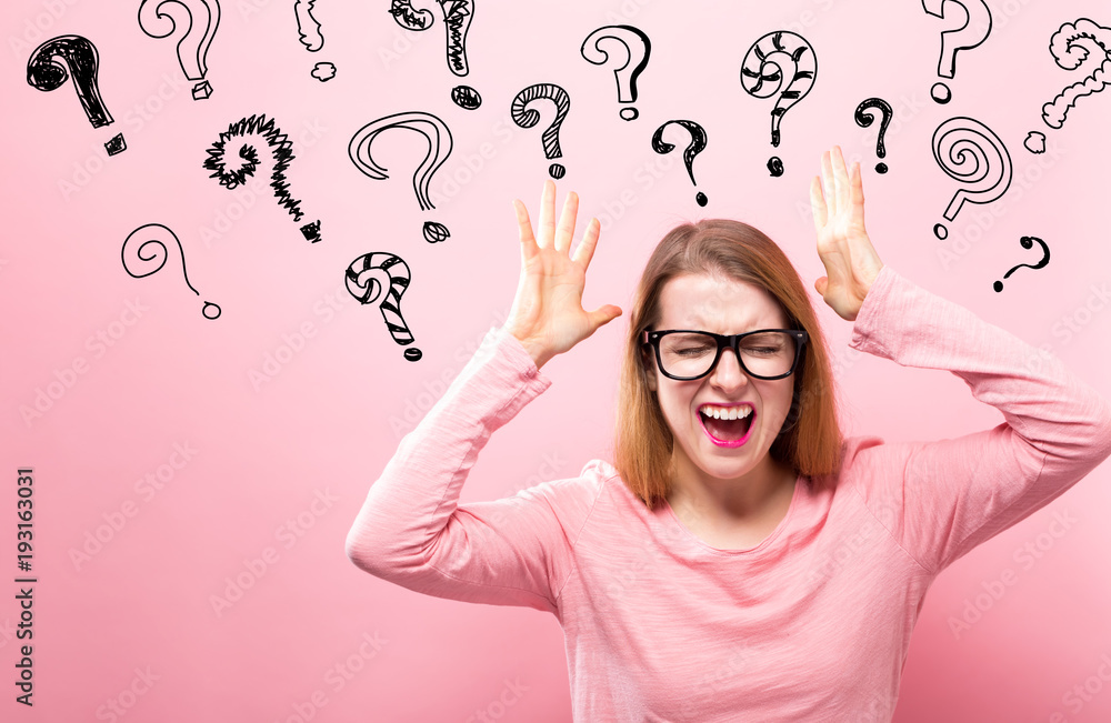 Wall mural question marks with young woman feeling stressed on a pink background