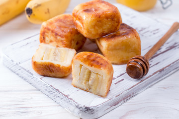 Cottage cheese pancakes in the form of cubes with honey on a white background