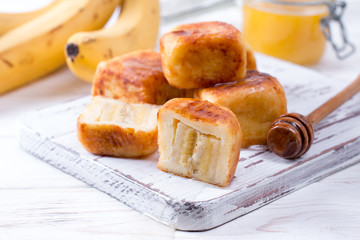 Cottage cheese pancakes in the form of cubes with honey on a white background