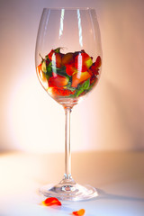 Glass vase filled with red rose petals. Aromatherapy concept.