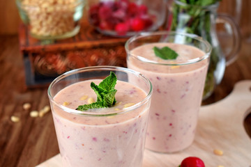 Protein cocktail for healthy nutrition with cranberries, mint and pine kernel nuts in a glass