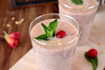 Protein cocktail for healthy nutrition with cranberries, mint and pine kernel nuts in a glass
