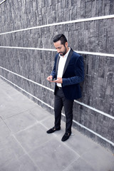 young businessman in suit texting outside office 