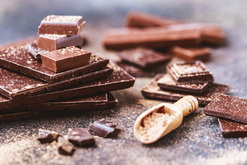Chocolate bar pieces. Background with chocolate. Sweet food photo concept. The chunks of broken chocolate