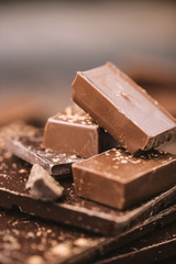Chocolate bar pieces. Background with chocolate. Sweet food photo concept. The chunks of broken chocolate