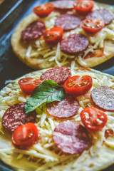 Mini Pizza With Cherry Tomatoes And Salami Sausages On A Wooden Background Natural Rustic, A Pizza Cutter And Ingridienty.
