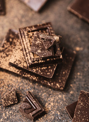 Chocolate bar pieces. Background with chocolate. Sweet food photo concept. The chunks of broken chocolate