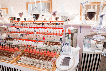 Delicious and tasty dessert table with cupcakes shots at reception closeup