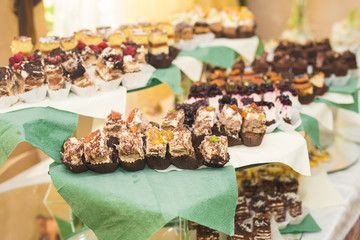 Delicious and tasty dessert table with cupcakes shots at reception closeup