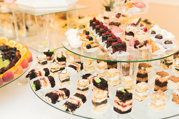Delicious sweets on wedding candy buffet with desserts, cupcakes
