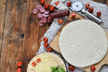 Homemade Round The Dough Base For A Pizza On Grunge Planks, Wooden Natural Background. The View From The Top. Copy space For Your Text