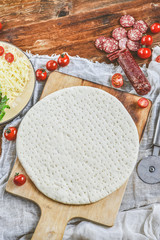Homemade Round The Dough Base For A Pizza On Grunge Planks, Wooden Natural Background. The View From The Top. Copy space For Your Text