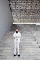 fashion businessman standing confident in stairs outside building