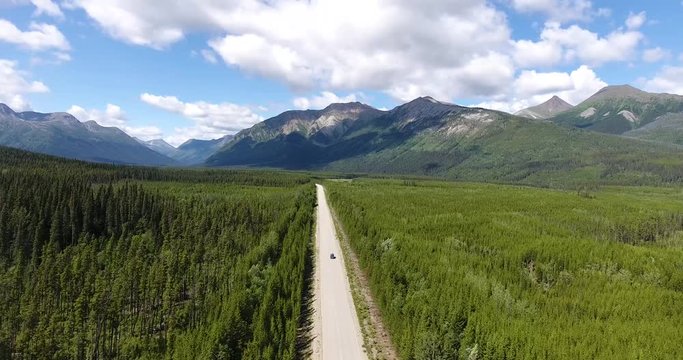 A van is driving on an empty wild street in the middle of nowhere