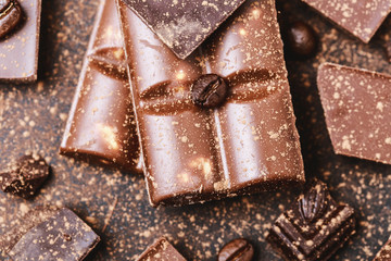 Chocolate bar pieces. Background with chocolate. Sweet food photo concept. The chunks of broken...