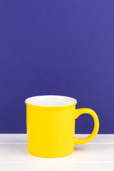 yellow cup with copy space purple background
