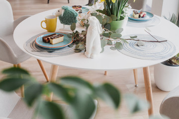 Beautiful spring table decoration with flowers and cake, close up
