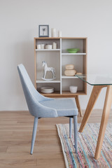 Light blue chair with table and wooden commode