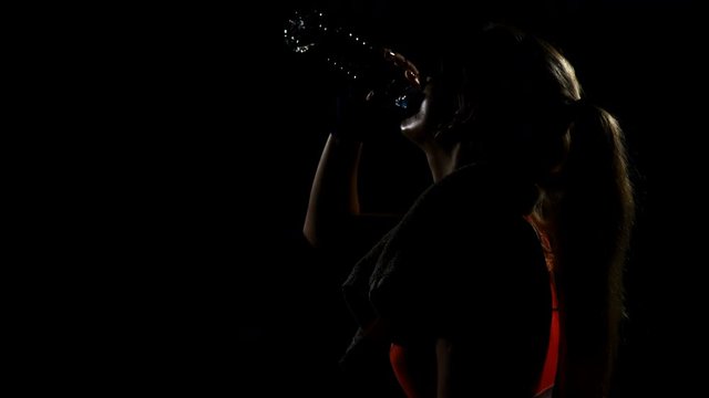 Female boxer drinking water and feeling exhausted after workout