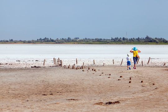 Two tourists among flat plain, steppe, salt, salt lake, heat and sky