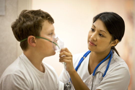 Doctor putting an oxygen mask on patient