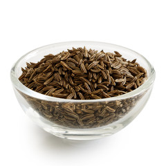 Caraway or cumin seeds in glass bowl isolated on white.