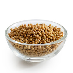 Dried white mustard seeds in glass bowl isolated on white.