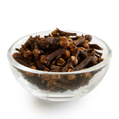 Whole cloves in glass bowl isolated on white.