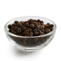 Whole black peppercorns in glass bowl isolated on white.