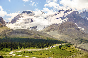 Mountains with ice field next to road with buses going to Columbia Icefield in Jasper National Park, Alberta, Canada