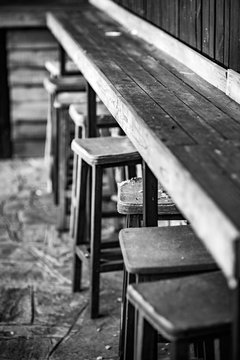 Very Old Weathered Wooden Chair Stools and Bench, Selective Focus on the most damaged one,  Black and White classic style photograph, Nostalgia for Old Photography