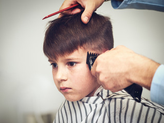 Fototapeta premium European boy getting haircut in barbershop.