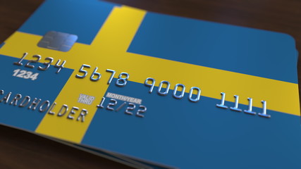 Plastic bank card featuring flag of Sweden. National banking system related 3D rendering