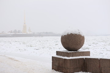 Russia, St. Petersburg, a granite ball on the river embankment during the snowfall