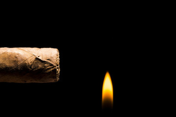 Cigar being lit on time on a black background
