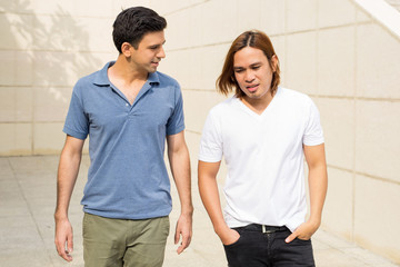 Two Young Men Walking and Talking Outdoors