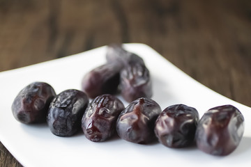 Dried dates on white plate.