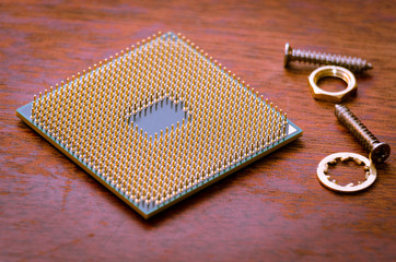 A square computer processor pulled from a broken computer. The processor is on the table. 