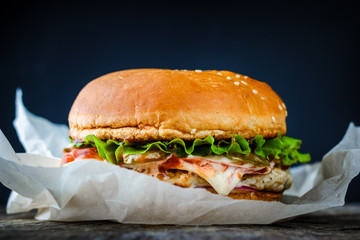 burger for takeaway, wrapped in paper on wooden table