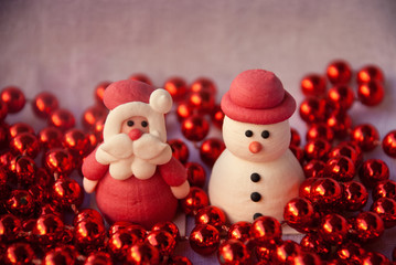 Figures of Santa Claus and Snowman with red garland. New year card. Merry christmas background. Xmas postcard.