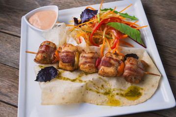 Baked fat on the skewer with salad
