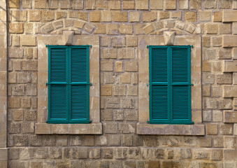 Windows with green shutters on an old house
