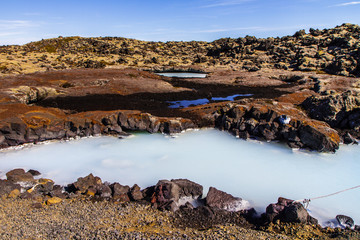 Rocky shore and crater lake in Iceland. Blue lagoon side view