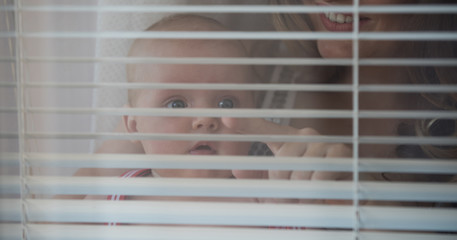 Woman with child point finger at window shutters