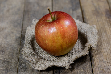 Big red apples in a dark wooden box. Wooden crate and apples on a wooden table in the kitchen.