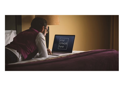 Mockup of Man with Laptop on Bed