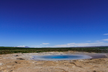 Bright blue sky above the valley of geysers in Iceland